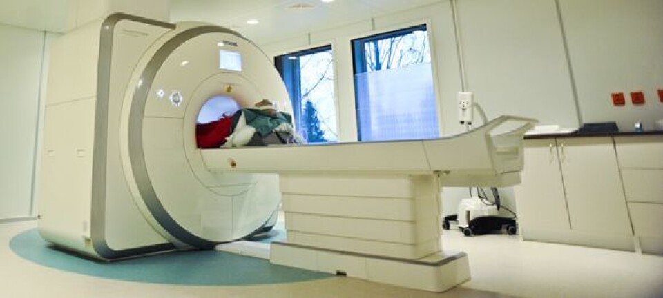 Første pasient ut i den nye MR-maskinen slapper av med radio på ørene mens maskinen lager bankelyder. Foto: Øyvind Blom, Haukeland universitetssjukehus.
